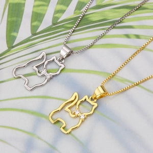 Detailed close-up of 18k gold and silver kitten pendants with zircon bows on box chains
