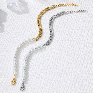Detailed shot of gold and silver plated Figaro chains merged with white pearls
