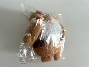 Detailed view of plush gingerbread man decoration in clear protective polybag packaging