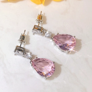 Macro shot of pink pear-cut cubic zirconia earrings with silver claw setting and star glow