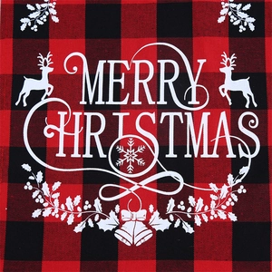 Close-up of red and black buffalo plaid fabric with white Merry Christmas reindeer print