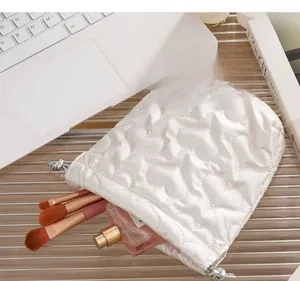 White quilted drawstring bag with heart texture storing makeup brushes and perfume