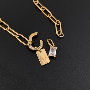 Close-up detail of a gold titanium steel necklace featuring a letter Y and zircon pendants
