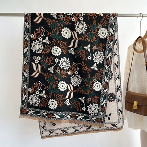 Detail of floral cashmere-feel scarf with elegant fringes and botanical pattern