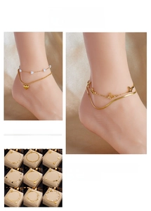 Collection of layered gold titanium steel anklets with butterfly, heart, and pearl charms