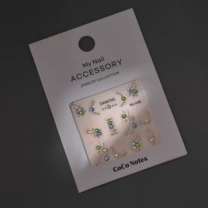 Detail view of MJ-038 nail accessory set with colorful rhinestones on a card