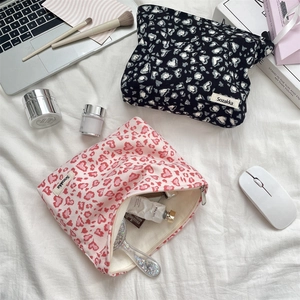 Flat lay of corduroy leopard print makeup bags with metal zipper and inner storage detail