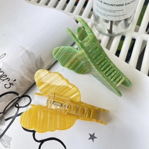 Close-up of butterfly hair claws with marble texture in vibrant yellow and green