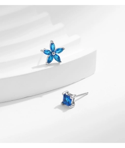 Detail view of S925 silver stud earrings with blue sapphire floral and square shapes