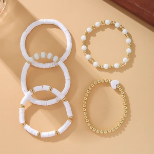 Detail of 5-piece Bohemian bracelet set with white clay beads and gold heart charm