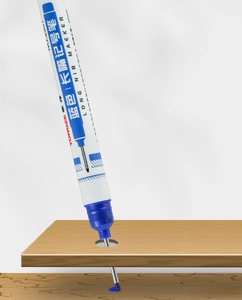 Blue 20mm long nib marker pen marking a deep hole on a wooden surface detail