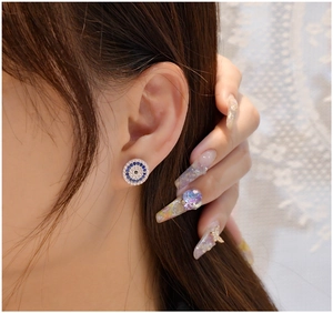 Close-up of circular blue and pink evil eye stud earring on model ear in 925 silver