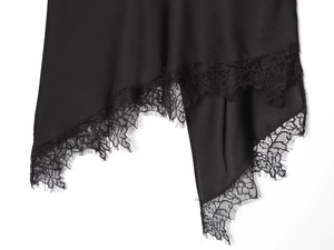 Detail of irregular black skirt hem featuring delicate eyelash lace stitching and texture