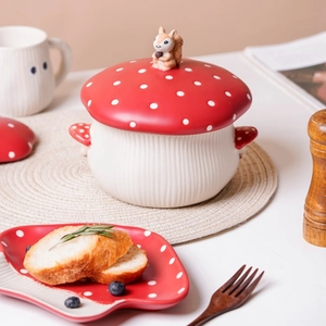 Detail of red mushroom ceramic bowl with squirrel lid handle in a cozy breakfast setting