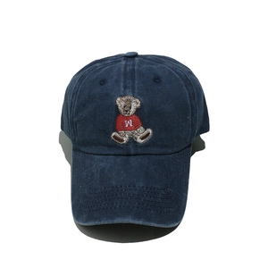 Detail der Bärenstickerei auf einer marineblauen Baseballkappe aus gewaschener Baumwolle