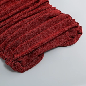 Macro d'un tissu plissé rouge pailleté avec des reflets métalliques brillants