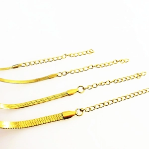 Detail of four golden stainless steel snake chain bracelets with adjustable extensions