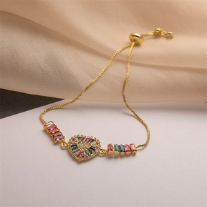 Detail of adjustable gold-plated bracelet with multi-color zircon heart and gemstones