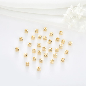Macro shot of 14K gold plated letter beads and heart charms for DIY jewelry making