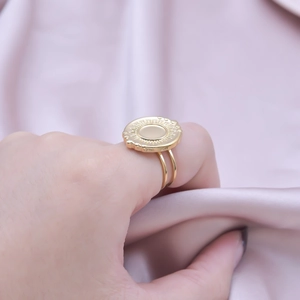 Detailed view of women's adjustable gold ring featuring a sunburst disc and double band