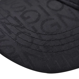 Detailed macro view of the black baseball cap brim with intricate jacquard letter patterns