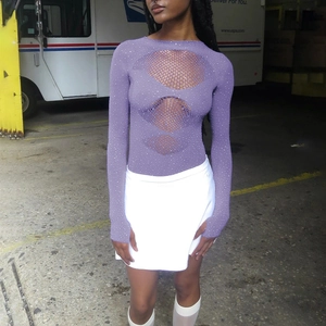 Détail d'un body en maille violette avec découpes ajourées et ornements en strass