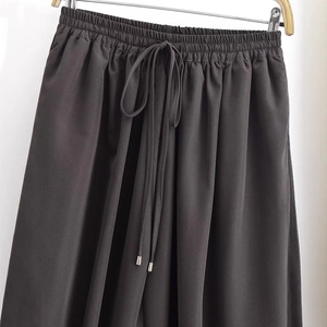 Charcoal loose pants with elastic bow waist and silver tips on clean white background