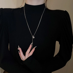 Silver Y-shaped adjustable necklace with geometric pendant on a black sweater