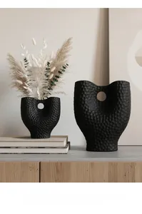 Détails de vases en céramique noir mat aux formes organiques et texture martelée unique