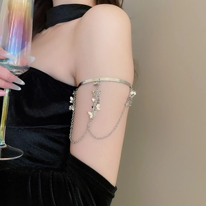 Detail of silver butterfly tassel arm cuff on upper arm with elegant dangling chains