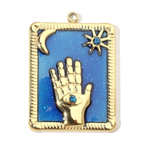 Detail of vintage gold-plated celestial pendant with blue enamel and star moon motifs