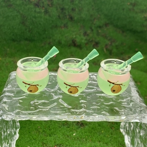 Detailed view of three glow-in-the-dark honey jar charms in pink and green gradients