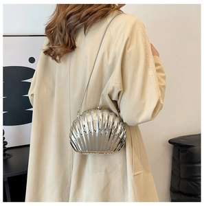 Detail of silver shell-shaped acrylic evening bag with metallic finish and chain strap