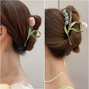 Elegant gold tulip and lily of the valley hair claws shown in professional hair styling
