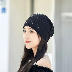 Detail of elegant black lace beanie hat for women featuring white pearl and rhinestone accents