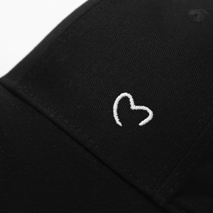 Close-up of white heart embroidery and high-quality black twill cotton on baseball cap