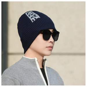 Detail of navy knit beanie with ribbed texture and FARD woven label on model