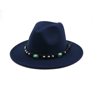 Vista dettagliata delle pietre turchesi su un cappello fedora in feltro blu navy.