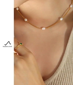 Detail of stainless steel flat chain necklace featuring natural freshwater pearl accents