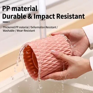 Rotating pink makeup brush holder made of thick PP material being washed under water