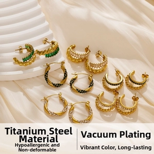 Detail of gold titanium steel earrings with vacuum plating and colorful zircon stones