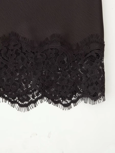 Detail aus schwarzem Satin mit edler Wimpernspitze und luxuriöser Textur-Nahaufnahme