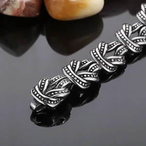 Vue macro d'un bracelet punk en acier titane avec noeuds celtiques et reliefs