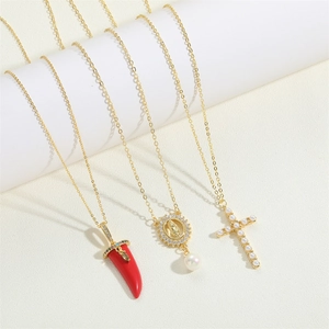 Detailed close-up of 14K gold plated necklaces featuring red chili, virgin mary and pearl cross