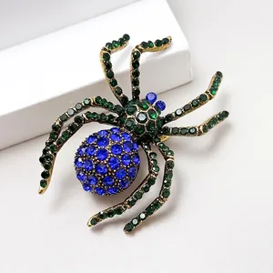 Macro shot of spider brooch with a deep blue crystal and green rhinestone details