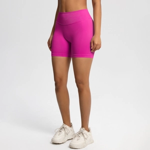 Detail showing high-waisted seamless peach lift sports shorts in rose red athletic fabric