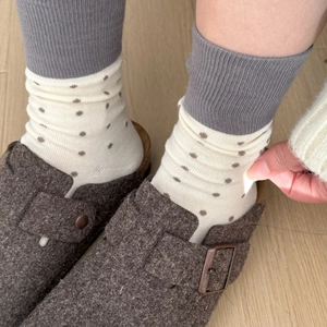 Close-up of beige polka dot cotton socks with grey ribbed cuffs and brown felt shoes