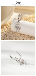 Macro view of gothic cross hoop earrings with pave cubic zirconia and colored stones