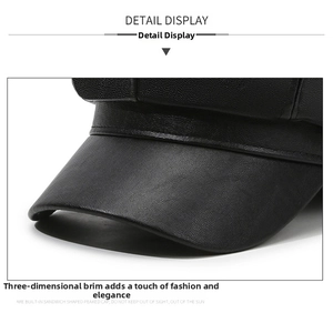 Detailed close-up of the black faux leather texture and brim stitching on newsboy cap