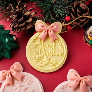 Christmas bow and bell fondant cookie mold with Merry Christmas lettering and snowflake pattern